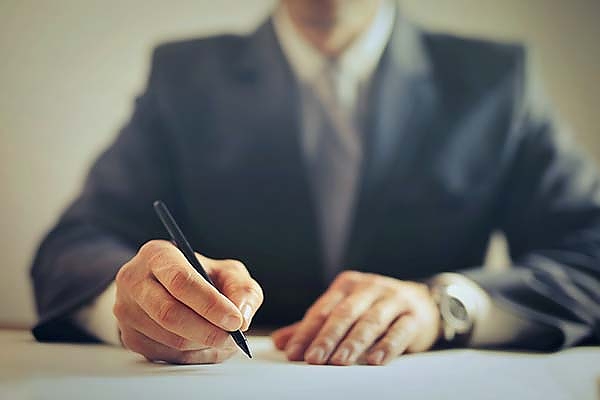 man signing a document