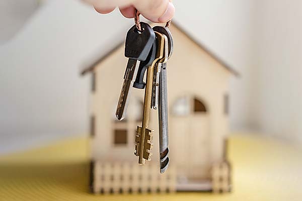 keys dangling in front of a model house